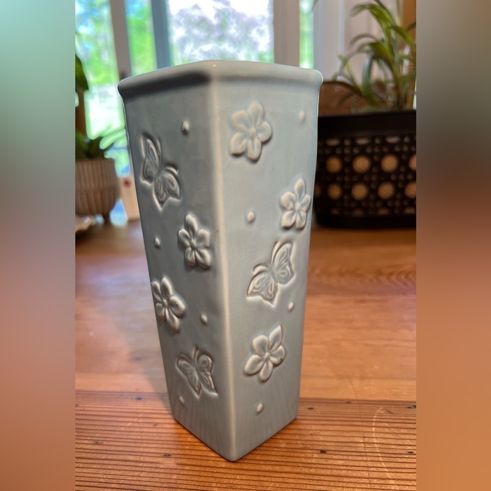 Small baby blue bud vase. With “butterflies and flowers.”